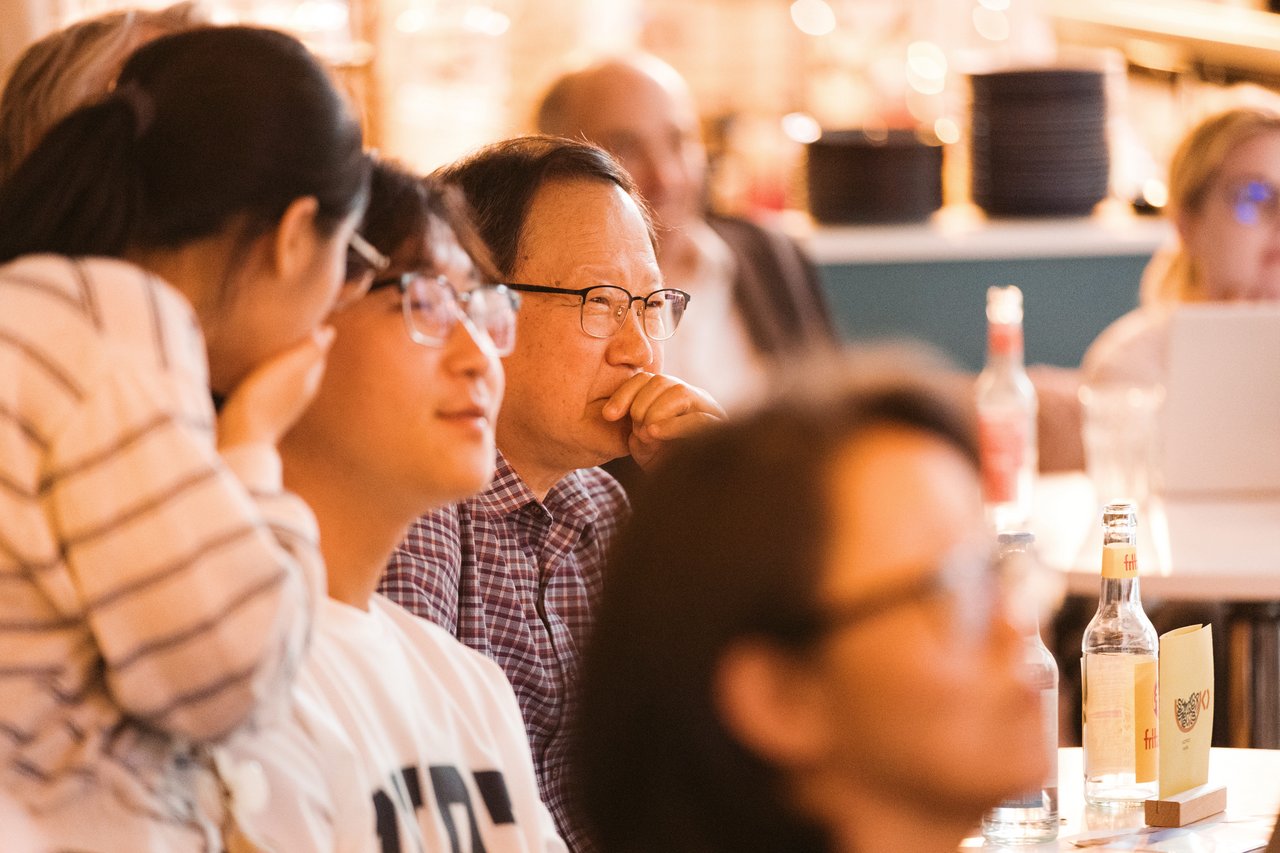 Im Publikum flüstern und kichern zwei koreanische Jugendliche