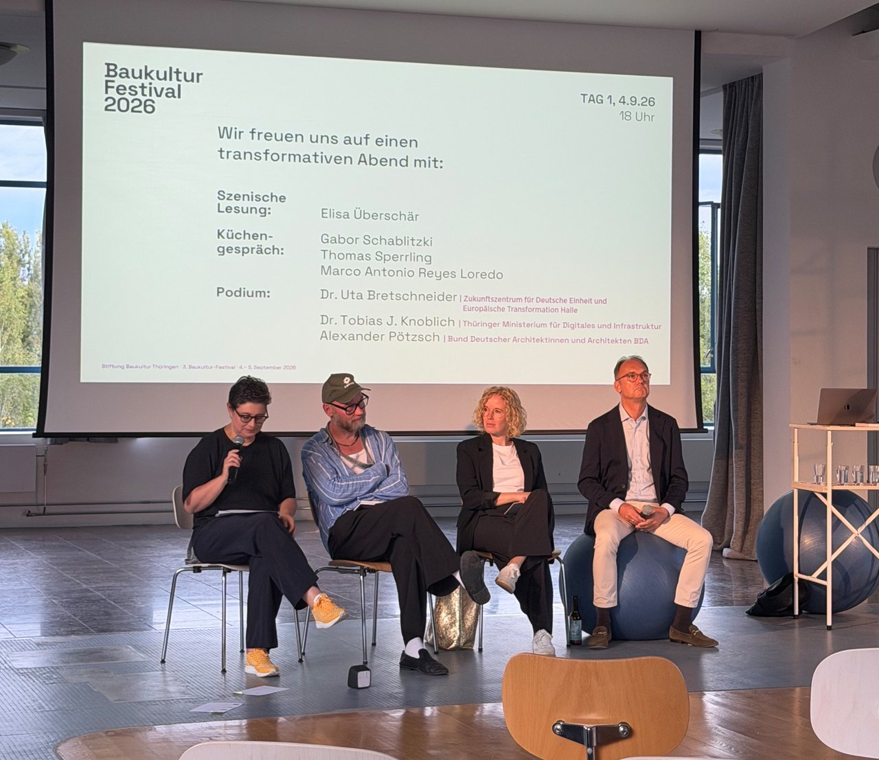 Vier Personen sitzen beim Baukultur-Festival in Apolda auf einem Podium vor einer Projektionsfläche.