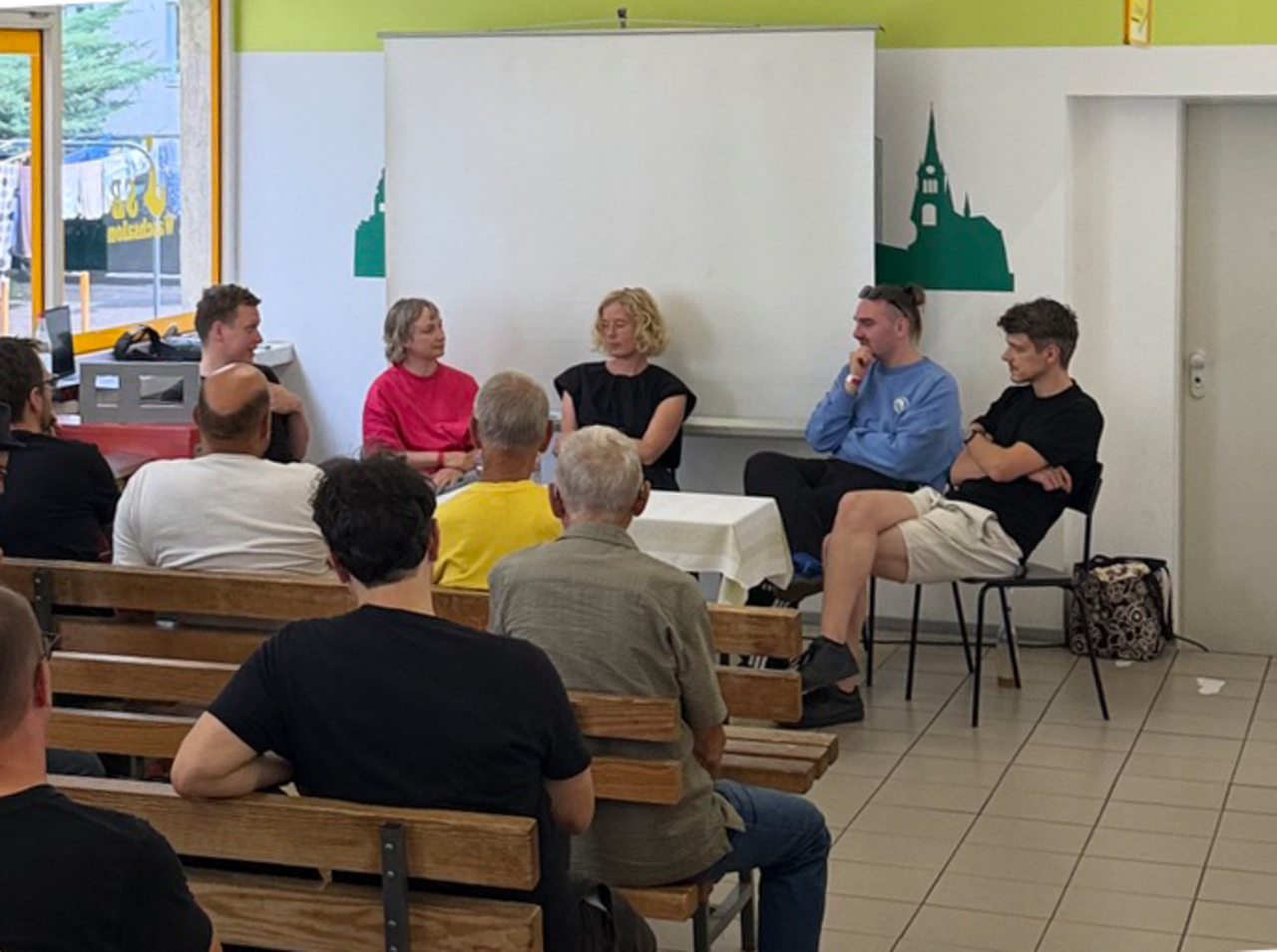 Mehrere Personen sitzen bei KOSMOS Chemnitz auf einem Podium vor Publikum.
